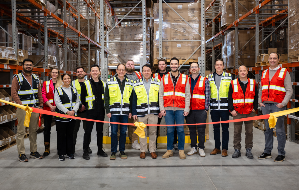 GoBolt and Sodastream teams at a GoBolt fulfillment warehouse, standing in front of stocked fulfillment racks