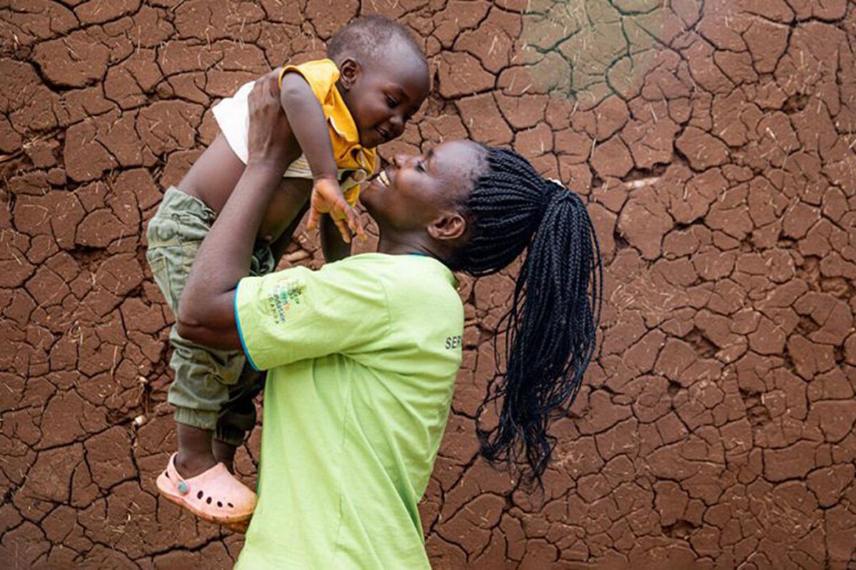 a woman holds up a baby