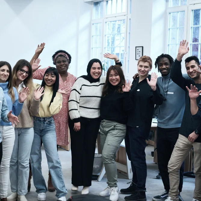 A big group of diverse people are smiling into the camera